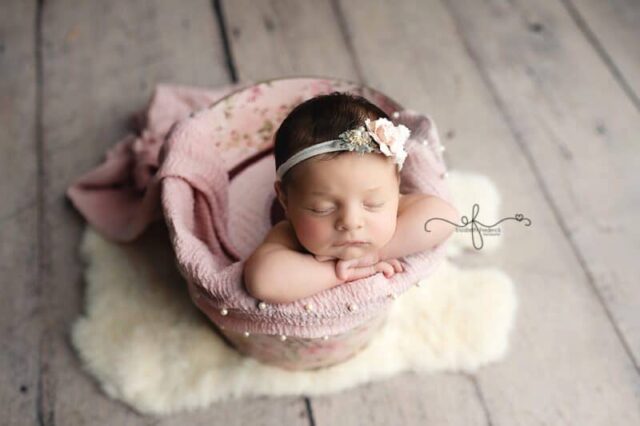 Pink newborn photography in Connecticut featuring a baby girl posed in a basket.