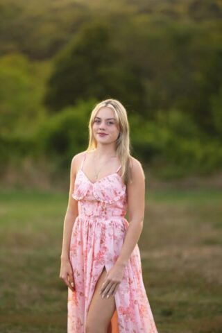 Connecticut high school senior photography session at Gouveia Vineyards in Wallingford CT, senior girl wearing a pink dress posing among vineyard rows.