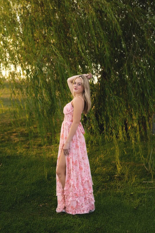 Connecticut high school senior photography session at Gouveia Vineyards in Wallingford CT, senior girl wearing a pink dress posing among vineyard rows.