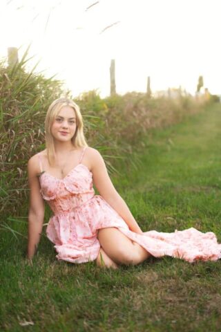 High school senior portrait at Gouveia Vineyards in Connecticut featuring a senior girl in a flowing pink dress with vineyard scenery.