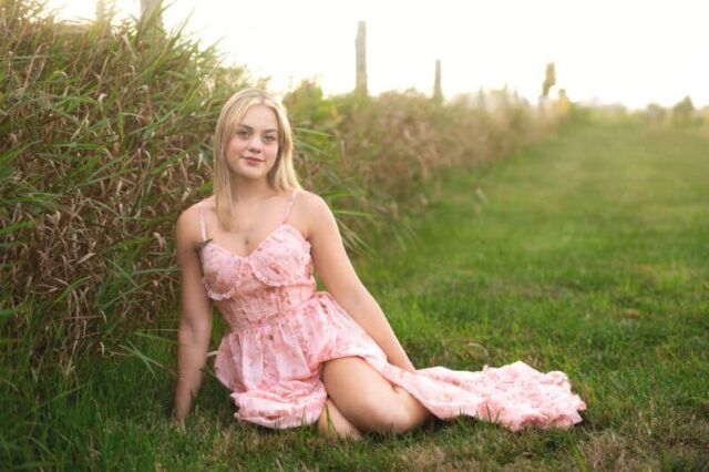 High school senior portrait at Gouveia Vineyards in Connecticut featuring a senior girl in a flowing pink dress with vineyard scenery.