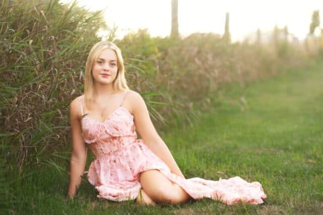 High school senior portrait at Gouveia Vineyards in Connecticut featuring a senior girl in a flowing pink dress with vineyard scenery.