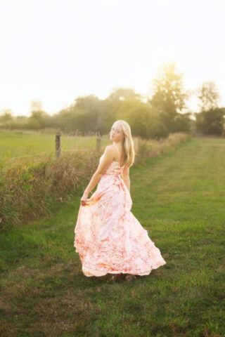 Connecticut high school senior photography session at Gouveia Vineyards in Wallingford CT, senior girl wearing a pink dress posing among vineyard rows.