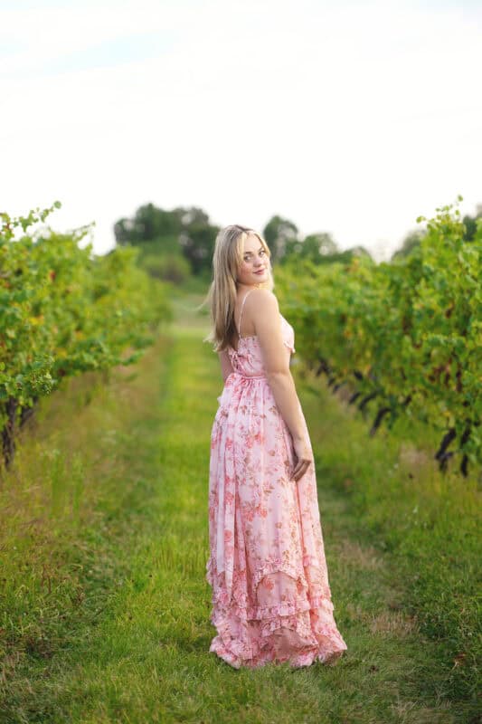 Wallingford CT senior photography session at Gouveia Vineyards, elegant senior portrait in a pink dress with rolling vineyard hills.